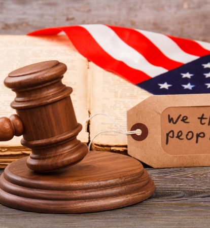 American court concept. We are the people slogan on the label. Brown wooden gavel.